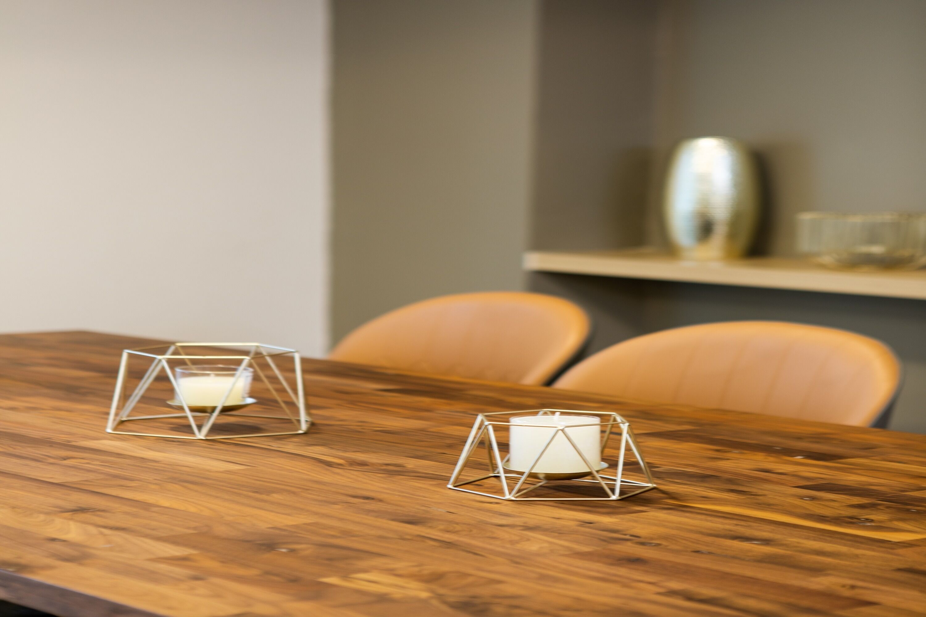 Uma mesa de madeira com dois castiçais geométricos.