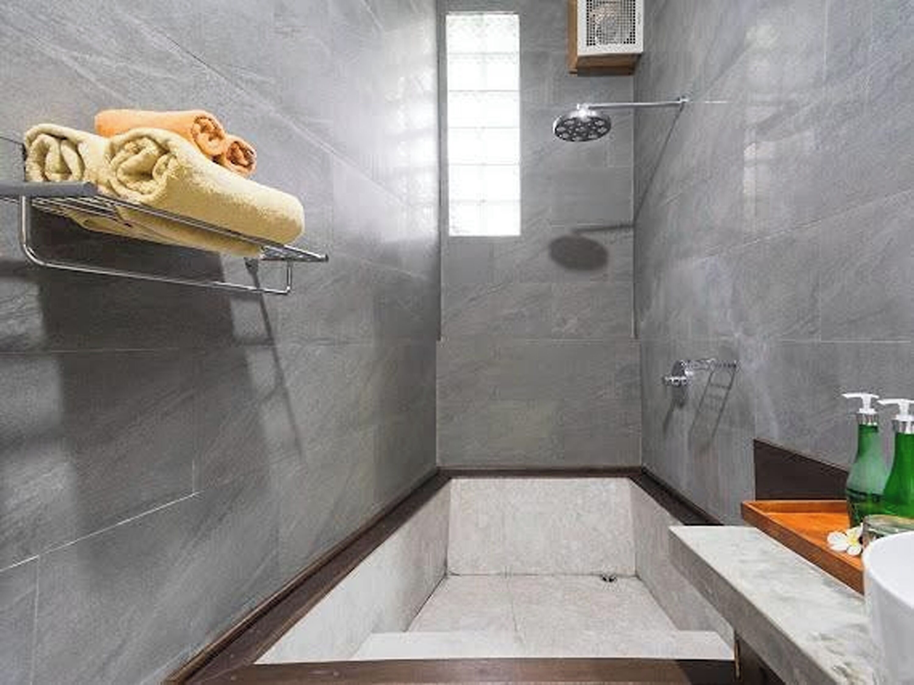 A modern bathroom with a shower, a towel rack, and a soap dispenser.