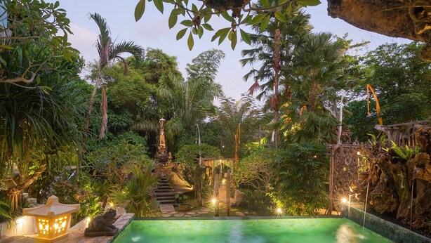 A serene outdoor pool area surrounded by lush greenery and stone pathways. - Nayaka Living Ubud (Ubud)