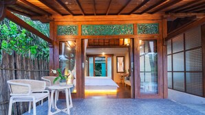 A traditional Japanese-style room with tatami mats, a low wooden ceiling, and sliding doors. - Nayaka Living Ubud (Ubud)