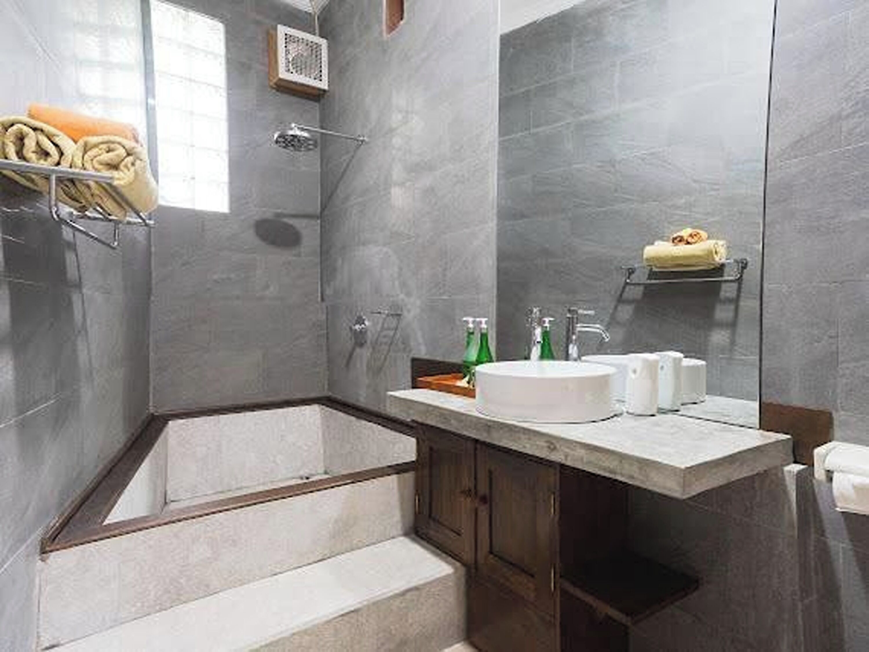 Un baño moderno con una bañera grande, un lavabo con espejo y una zona de ducha.