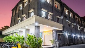 A hotel with a modern facade, multiple windows, and a well-lit entrance. - Ganandra Stay Denpasar (Denpasar)