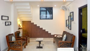 A modern interior with a staircase, wooden furniture, and a fan. - Paradise Homestay Civil Lines, Only Family & Corporate Stays (Nagpur)