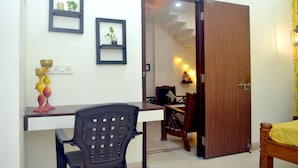 A room with a desk, a chair, a bed, and a door leading to another room. - Paradise Homestay Civil Lines, Only Family & Corporate Stays (Nagpur)