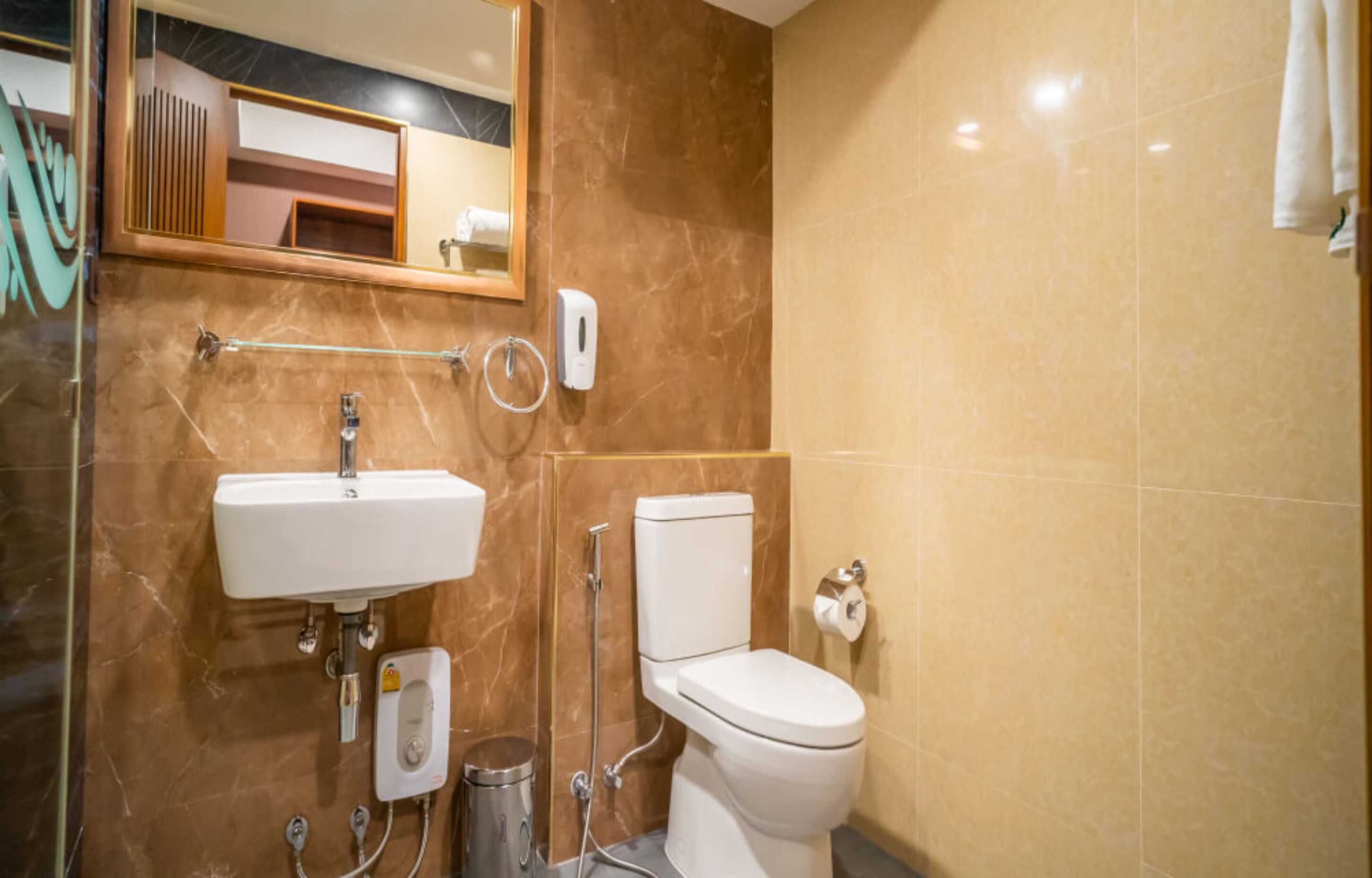 A bathroom with a sink, toilet, and hand dryer.