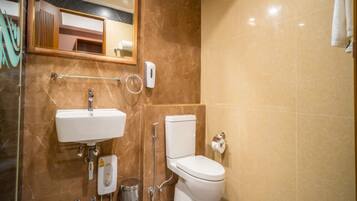 A bathroom with a sink, toilet, and hand dryer.