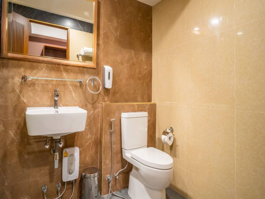A bathroom with a sink, toilet, and hand dryer.