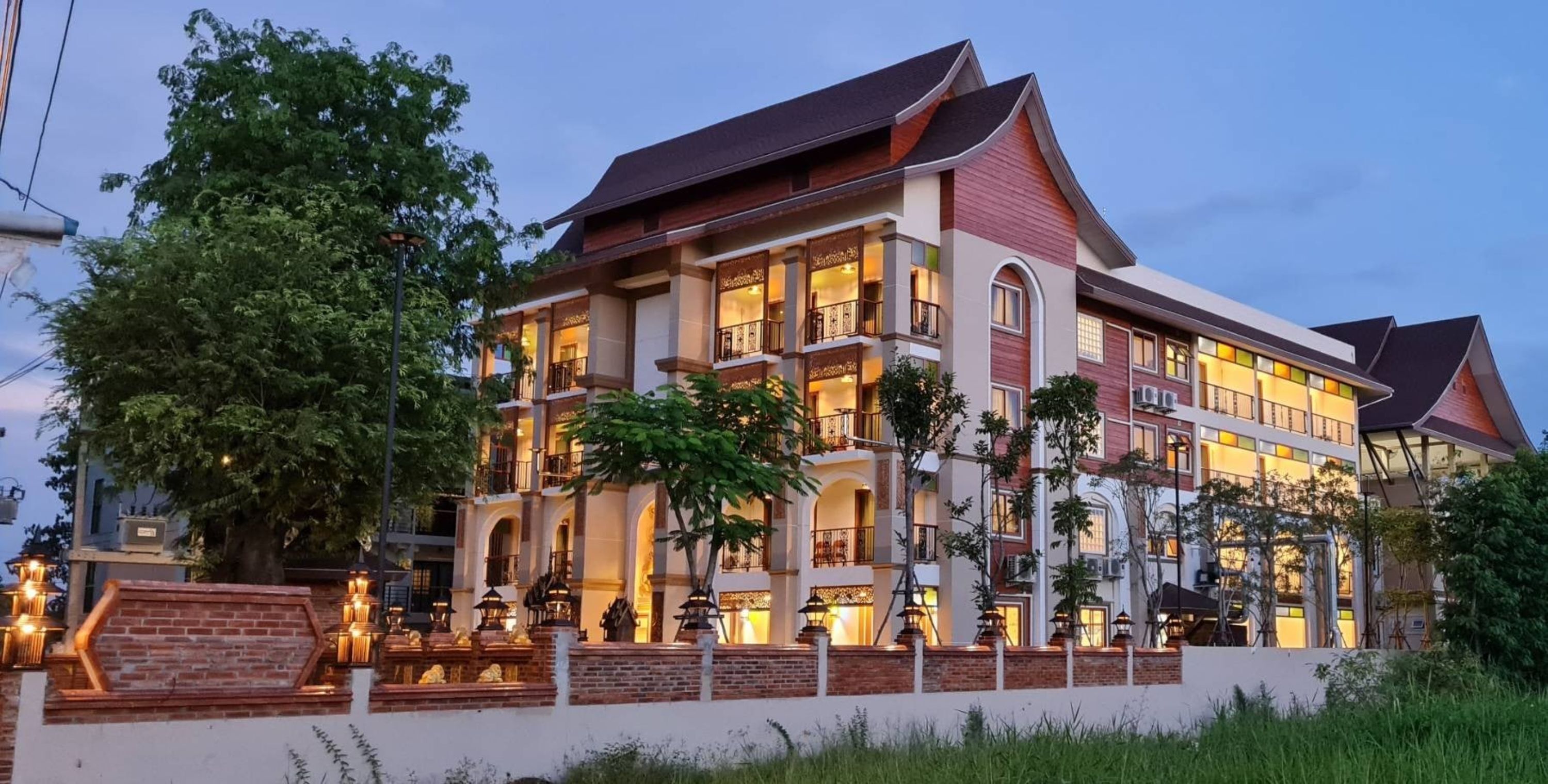 A multi-story hotel with a traditional architectural style, featuring balconies and large windows.