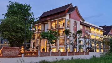 A multi-story hotel with a traditional architectural style, featuring balconies and large windows.