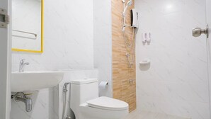 Un baño moderno con lavamanos, inodoro y ducha blancos.
