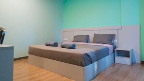 Un dormitorio moderno con una cama grande, una mesita de noche y un escritorio.