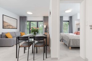 Ett modernt hotellrum med en matplats, en soffa och en säng.