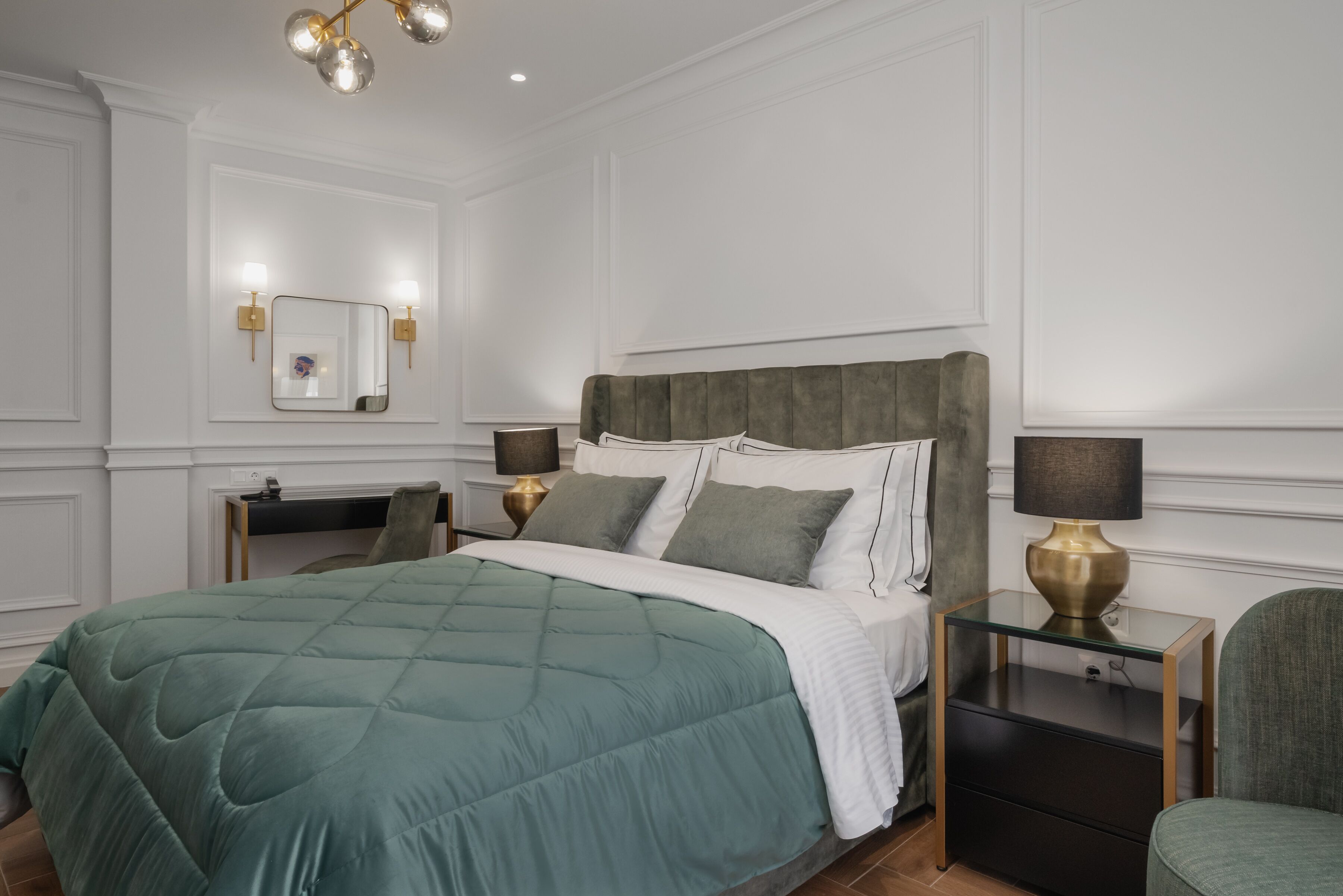 A neatly arranged bedroom with a large bed, bedside tables, and a mirror.