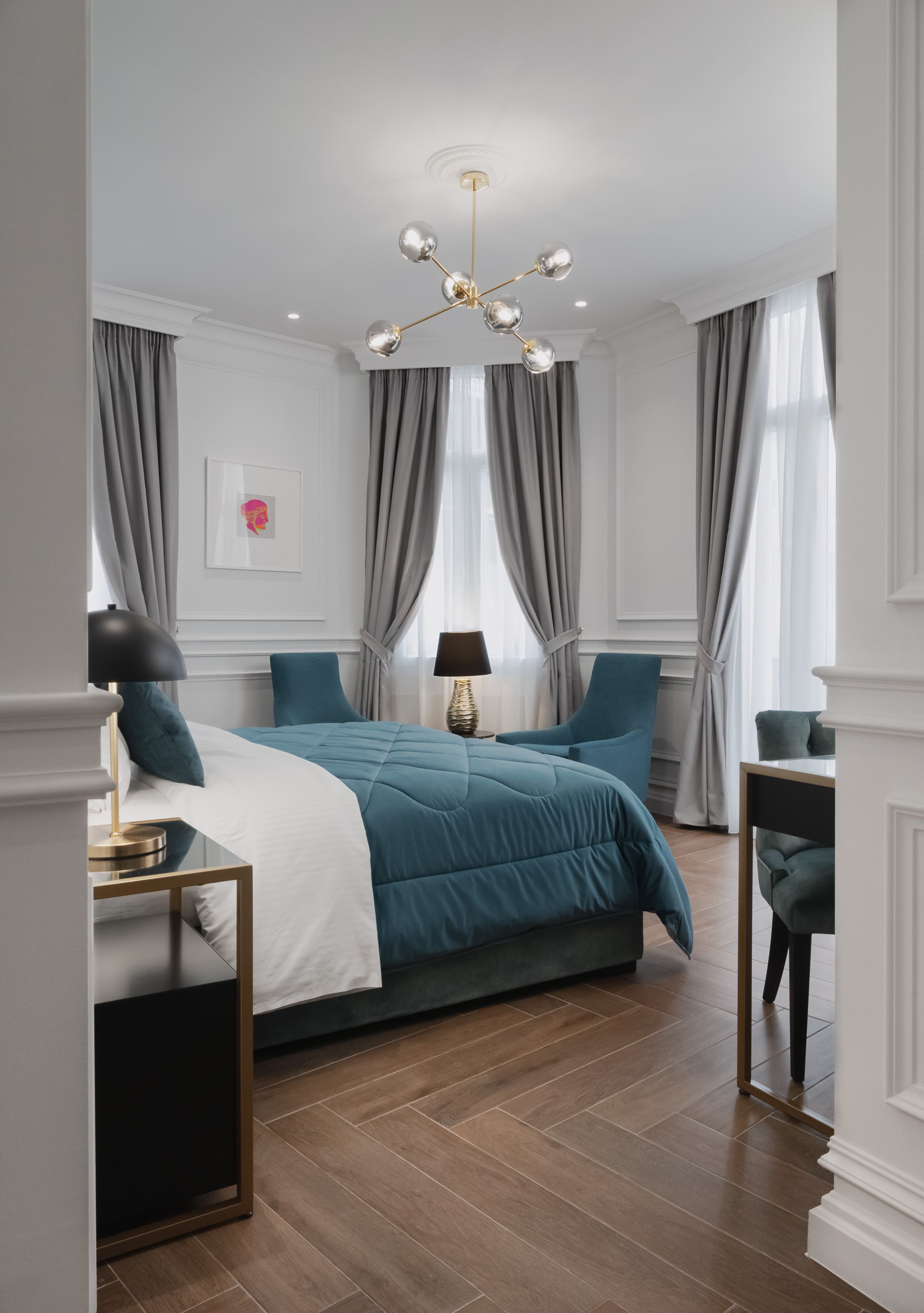 A modern bedroom with a large bed, a chandelier, and a view of the city.