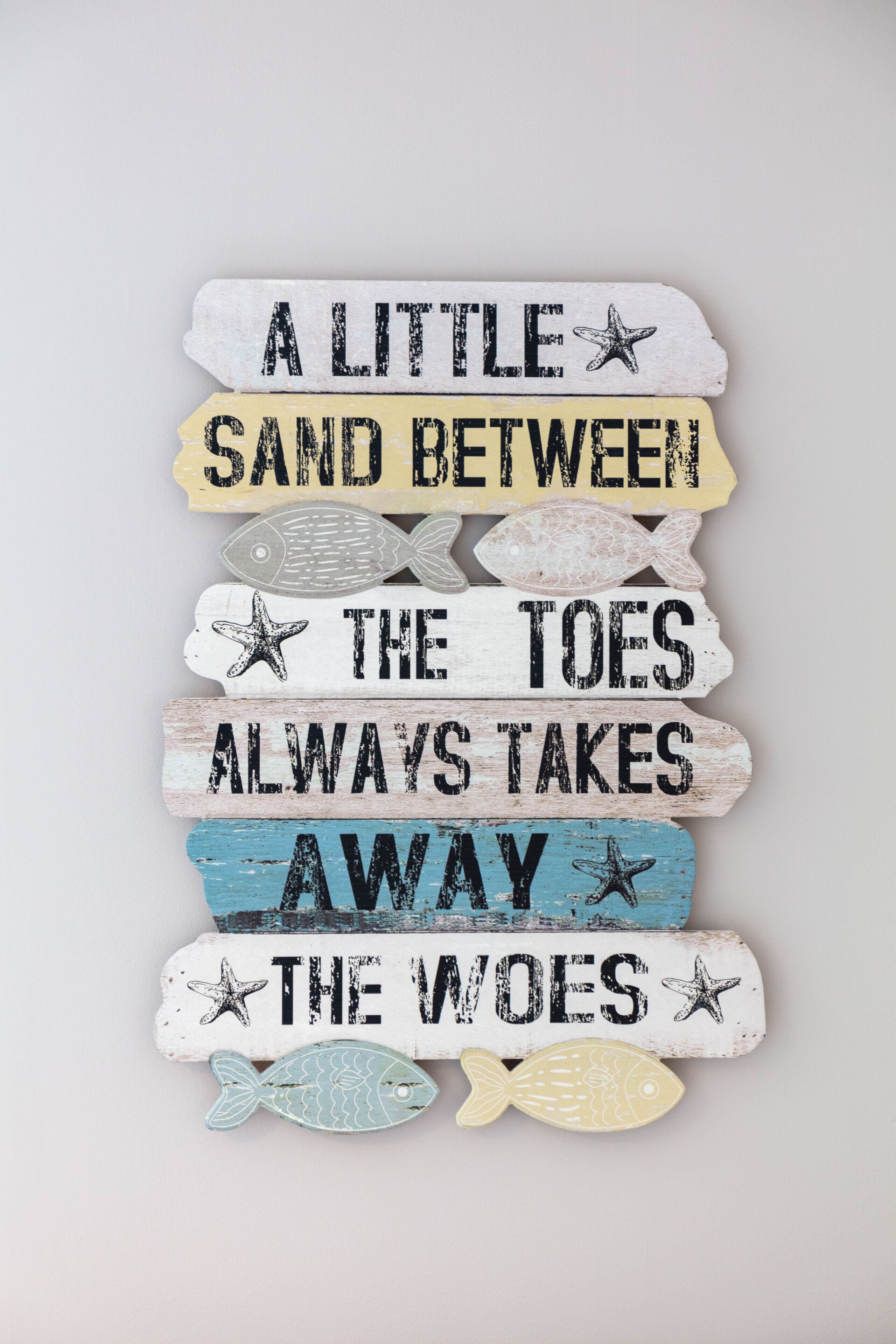 Un letrero decorativo con temática náutica, que incluye texto e ilustraciones de estrellas de mar.