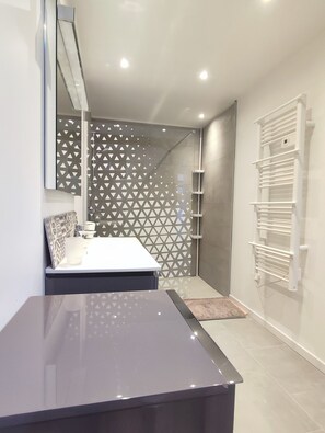 A modern bathroom with a shower, a towel rack, and a sink. - Ancienne Bergerie Rénovée , Proche des Lacs, Sentiers Pédestres (COMPS LA GRANDVILLE)