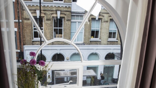 Une pièce dotée d’une grande fenêtre en arc d’où l’on a vue sur la rue.