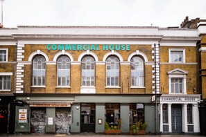 Un bâtiment sur lequel on peut lire l’inscription « IMMEUBLE COMMERCIAL » au-dessus de l’entrée.