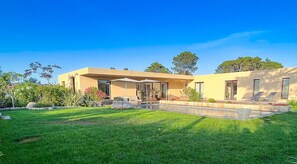 A modern house with a well-maintained lawn and outdoor seating area. - New villa in St. Cyprien, just a few minutes' walk from the beach (Lecci)
