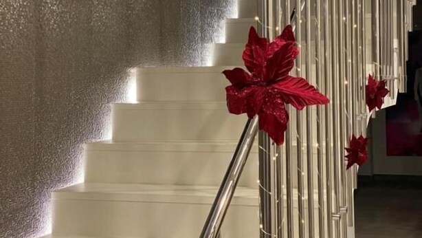 A staircase with a metallic railing and red decorative elements.