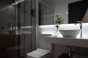 Habitación individual Deluxe | Baño | Regadera, regadera tipo lluvia, toallas, jabón 