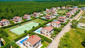 Et boligområde med flere toetagers huse, en tennisbane og en swimmingpool.