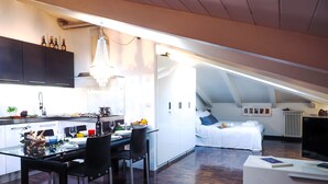 Eine moderne Lofts-Wohnung mit Küche, Essbereich und Schlafgelegenheiten.