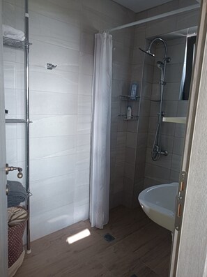 Appartement | Badkamer | Een douche, een haardroger, handdoeken