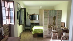 Una habitación pequeña con cama, escritorio y silla.