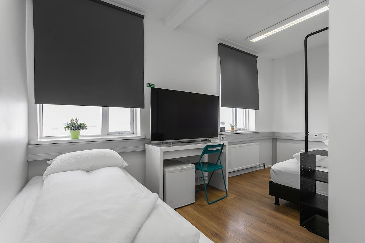 Vierpersoonskamer, gedeelde badkamer | Een minibar, een bureau, verduisterende gordijnen, geluiddichte muren