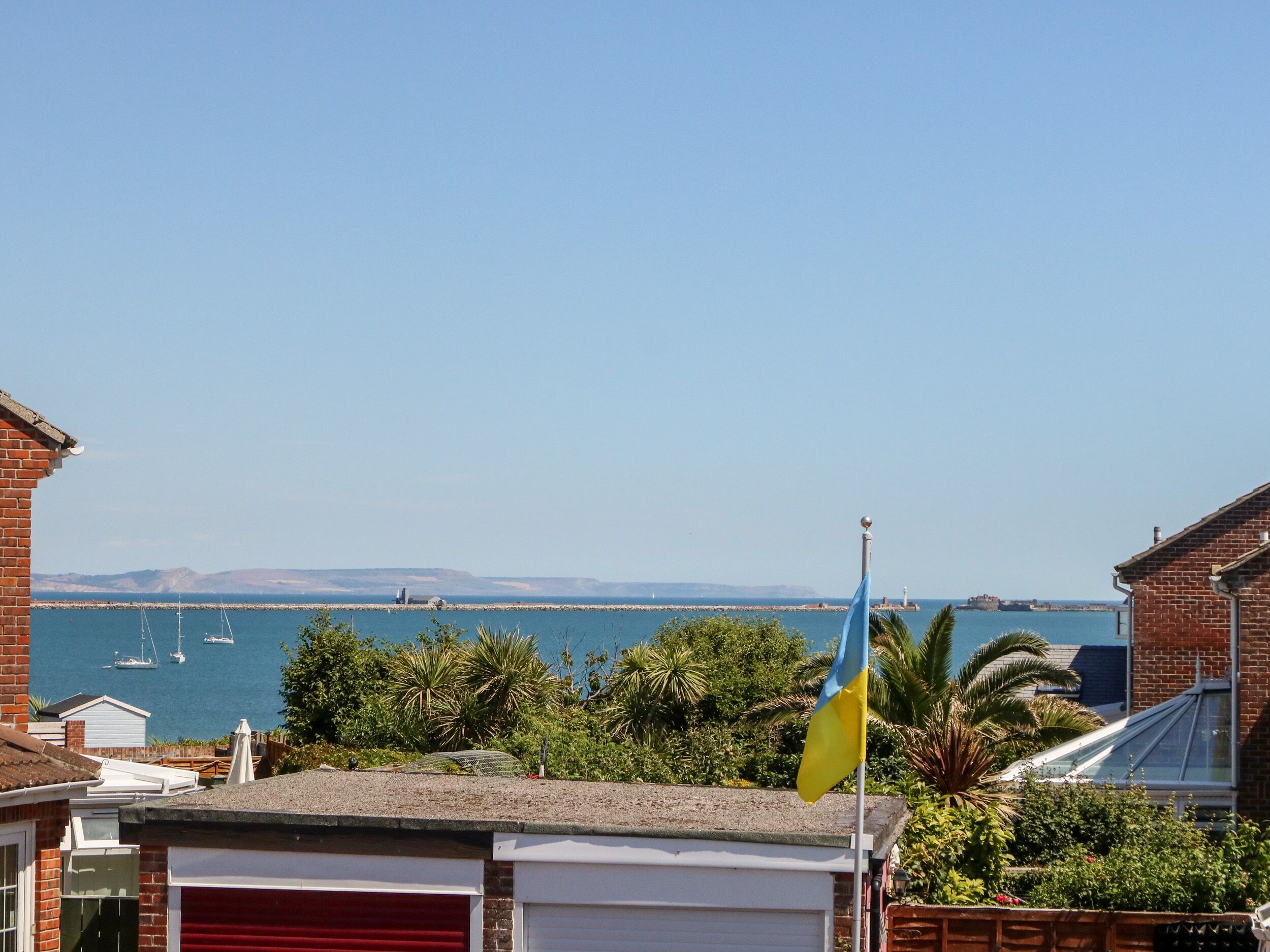 Ein Wohngebiet mit Blick auf das Meer, inklusive Boote und einer entfernten Insel.
