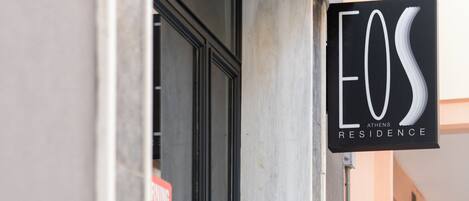 A hotel entrance with a sign reading "EOS ATHENS RESIDENCE".