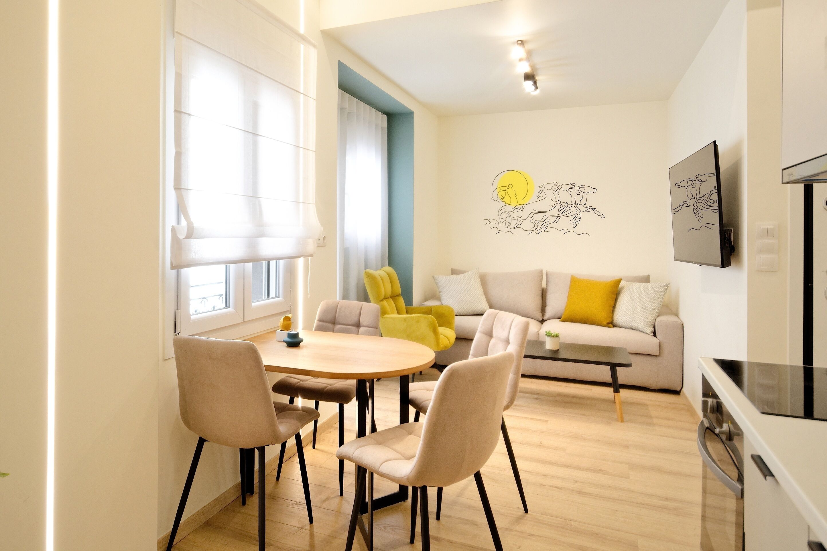 Uma sala de estar moderna com um sofá, uma mesa de jantar com cadeiras e uma área de cozinha com fogão.