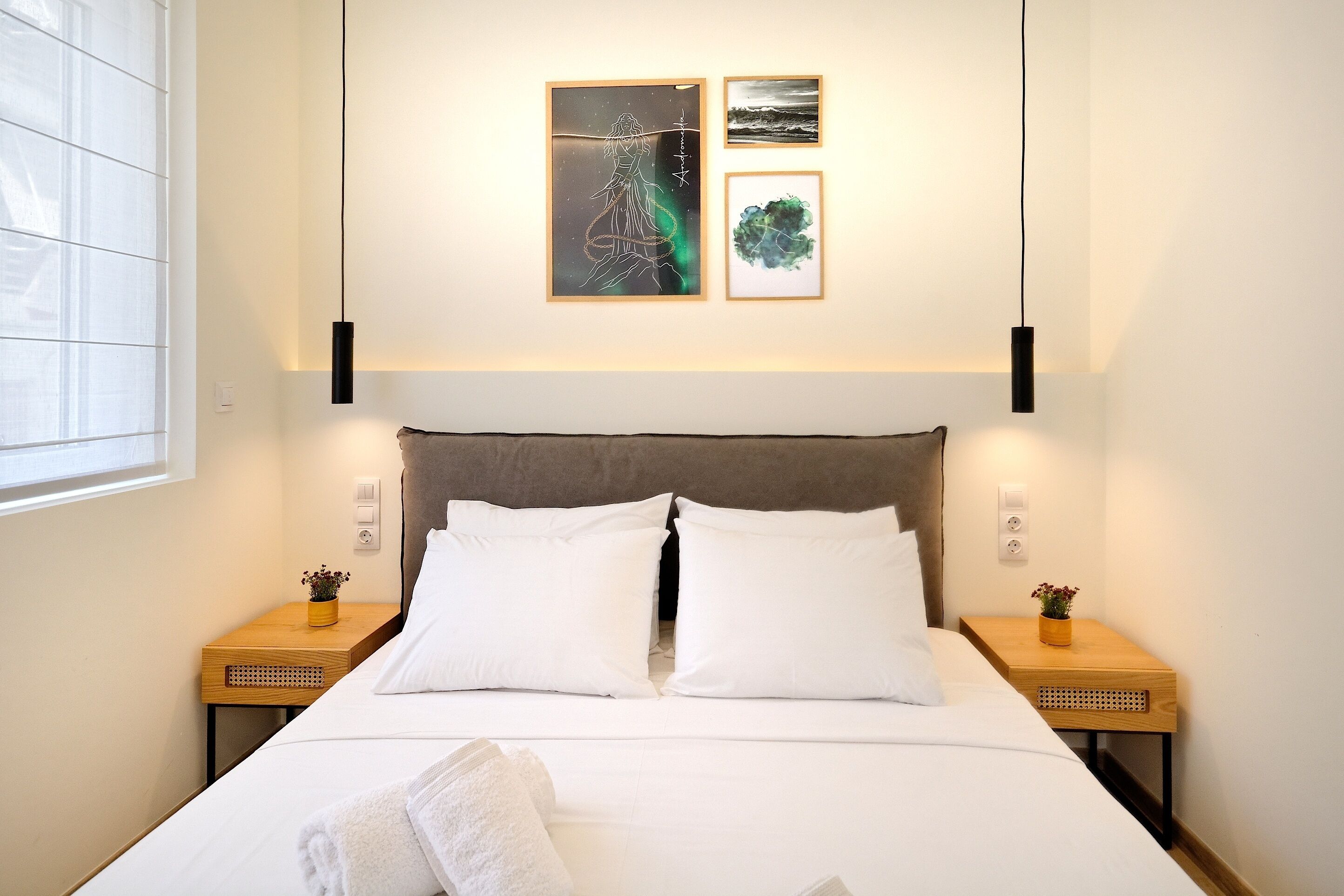 A modern hotel room with a large bed, two bedside tables, and artwork on the wall.