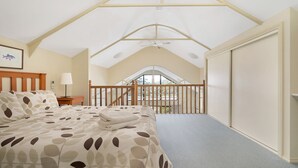A bedroom with a bed, a nightstand, a lamp, a ceiling fan, and a view of a balcony with a railing. - Valley Vista - Three bedroom villa located on golf course with amazing views! (Kangaroo Valley)