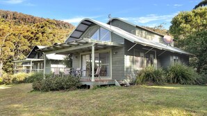 A house with a large porch, a satellite dish, and a view of a forested hillside. - Valley Vista - Three bedroom villa located on golf course with amazing views! (Kangaroo Valley)