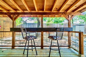 A wooden deck with two bar stools and a wooden table. - Perfect Private Getaway in Buchanan Lake Village! (Tow)