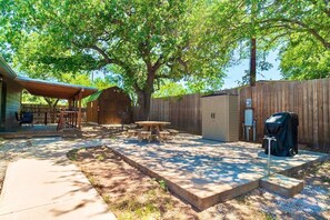 A backyard with a covered patio, a barbecue grill, a wooden shed, and a picnic table. - Perfect Private Getaway in Buchanan Lake Village! (Tow)