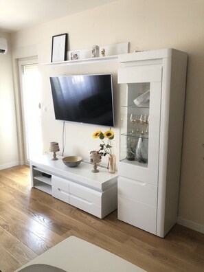 Relax in this stylish living room with a flat-screen TV, entertainment unit, and comfortable seating area.