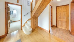 A wooden staircase with a handrail, leading to a second floor. - 3 bedroom accommodation in Cerrigydrudion (Cerrigydrudion)