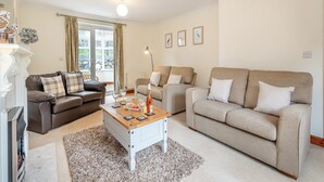 A living room with two sofas, a coffee table, and a fireplace. - 3 bedroom accommodation in Cerrigydrudion (Cerrigydrudion)