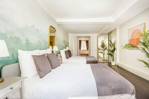 Habitació d'hotel amb dos llits, un mirall gran, una taula i vista al passadís.
