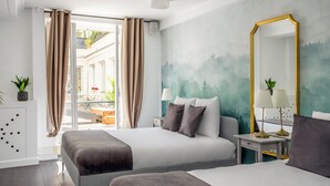 Une chambre d’hôtel avec deux lits, un grand miroir et une vue sur un espace extérieur doté d’un balcon.