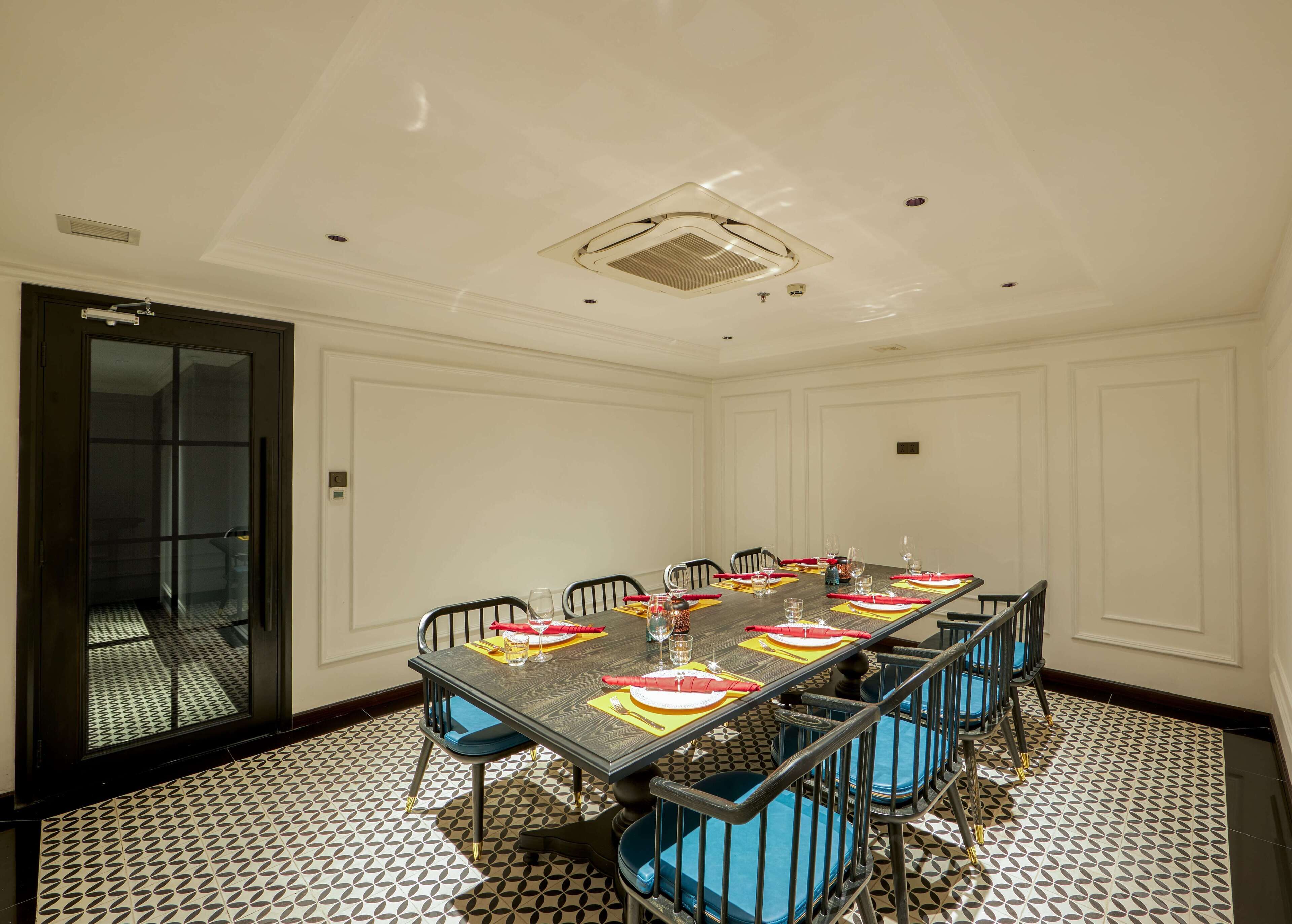 A conference room with a long table, chairs, and a patterned floor.
