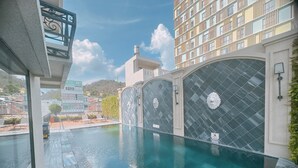 A swimming pool with a tiled wall and a water feature. - Hotel DMelin (Ho Chi Minh City)
