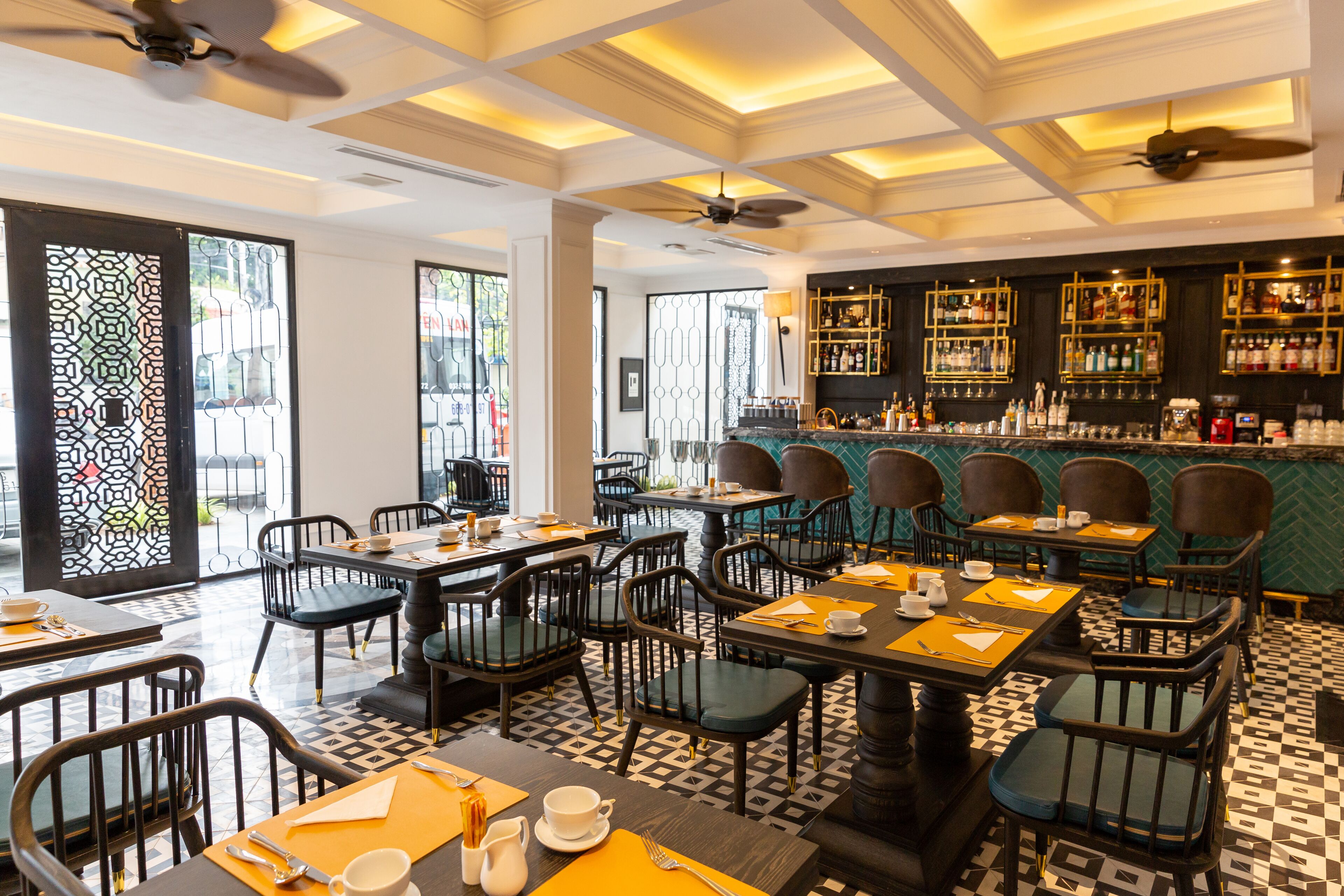 A restaurant with a bar area, tables with chairs, and a patterned floor.