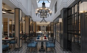A spacious dining area with a high ceiling, ornate chandeliers, and a patterned floor. - Hotel DMelin (Ho Chi Minh City)
