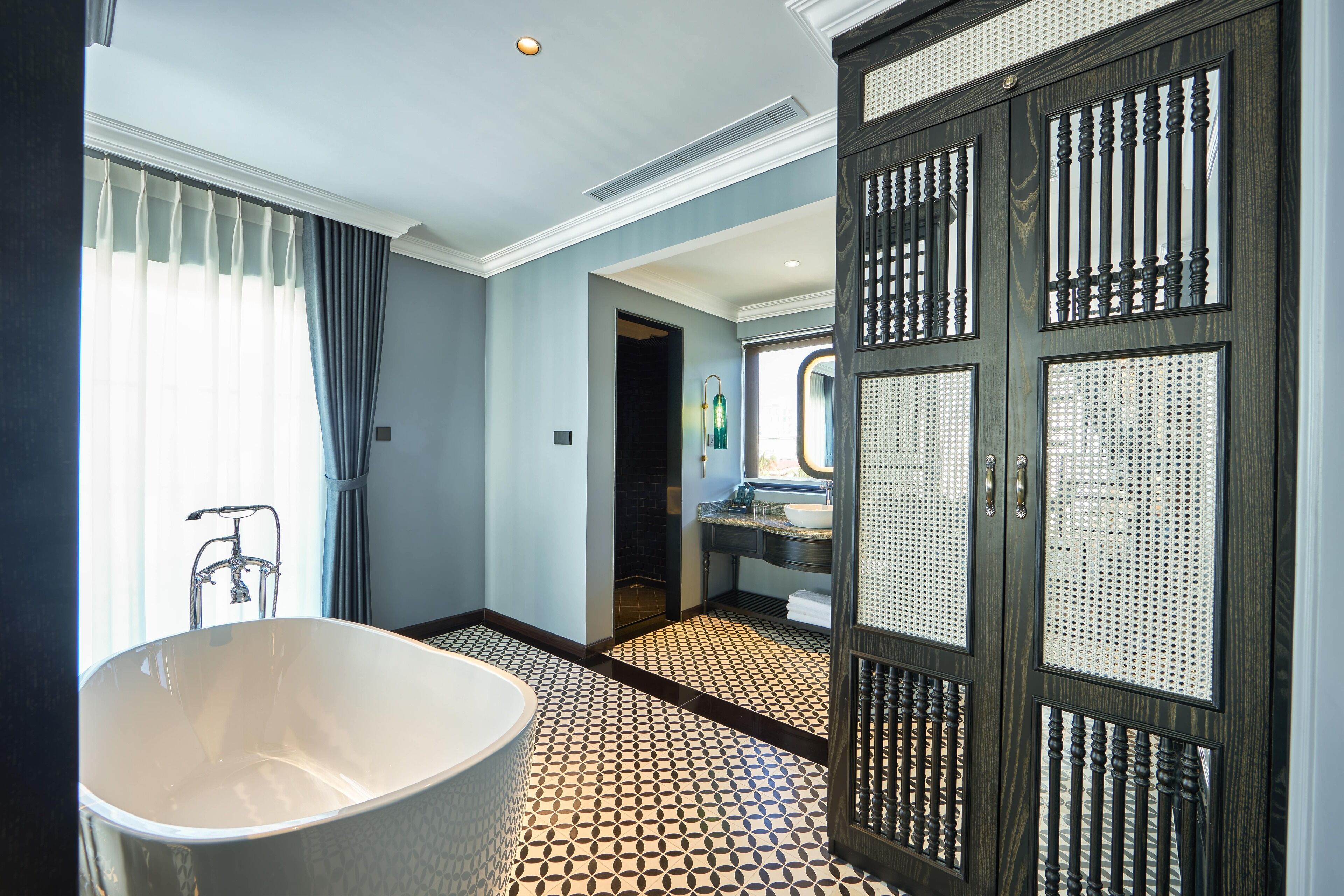 Ein Badezimmer mit freistehender Badewanne, Dusche und Waschbecken inklusive Spiegel.