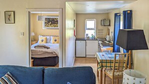Un espacio habitable compacto con cama, kitchenette y comedor.