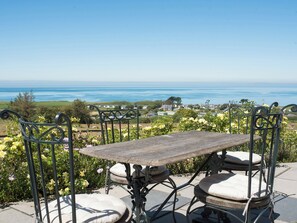 A table and chairs with a view of the ocean. - 3 bedroom accommodation in Nefyn, Llyn Peninsula (Nefyn, Llyn Peninsula)